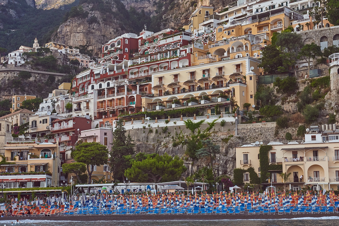 Positano from the water, terraced hotels, beach umbrellas, Amalfi Coast